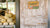 Melons at a farm stand with an old wooden door and sign giving the times open for business. 