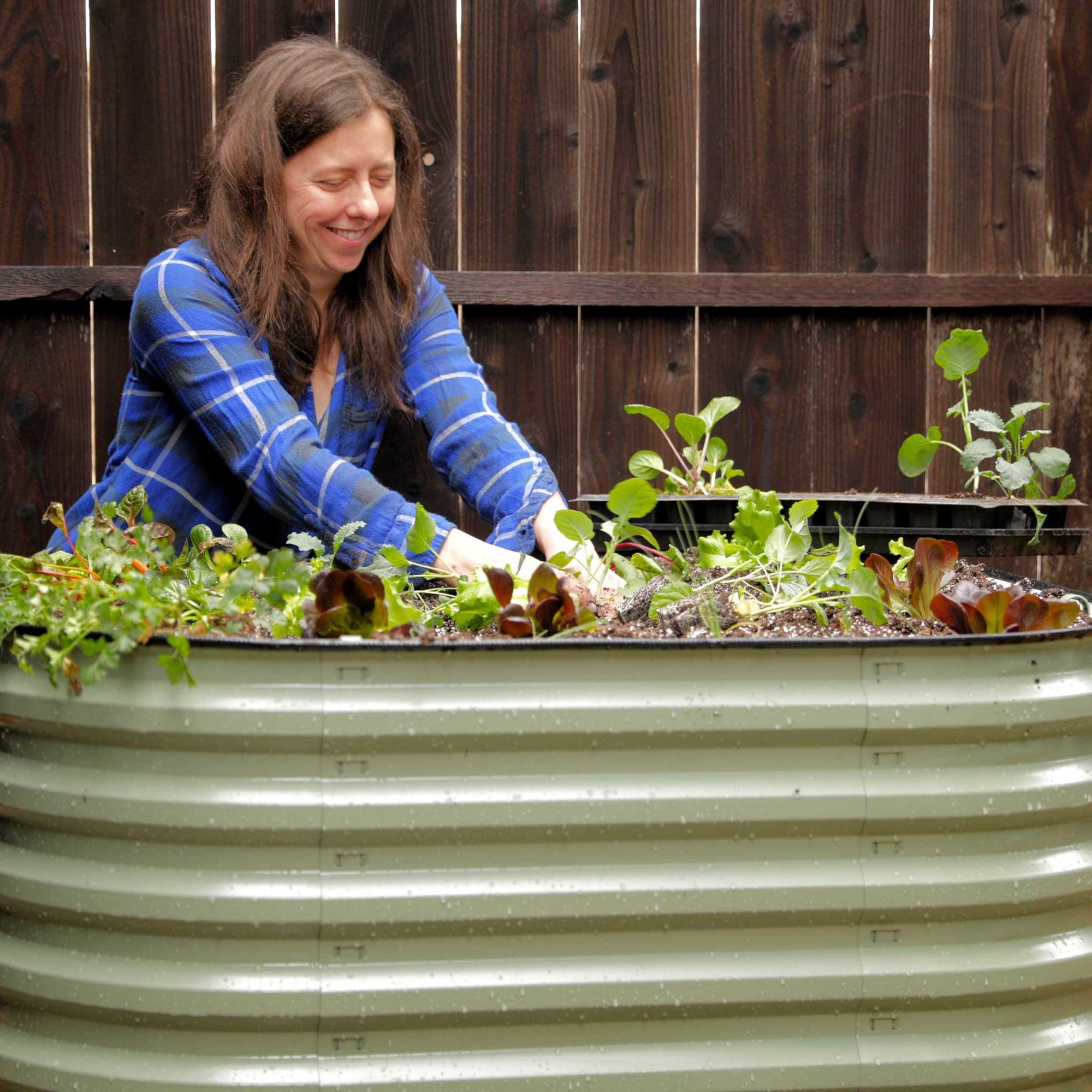 Gardener planting in to green modular system in 3' x 5' 