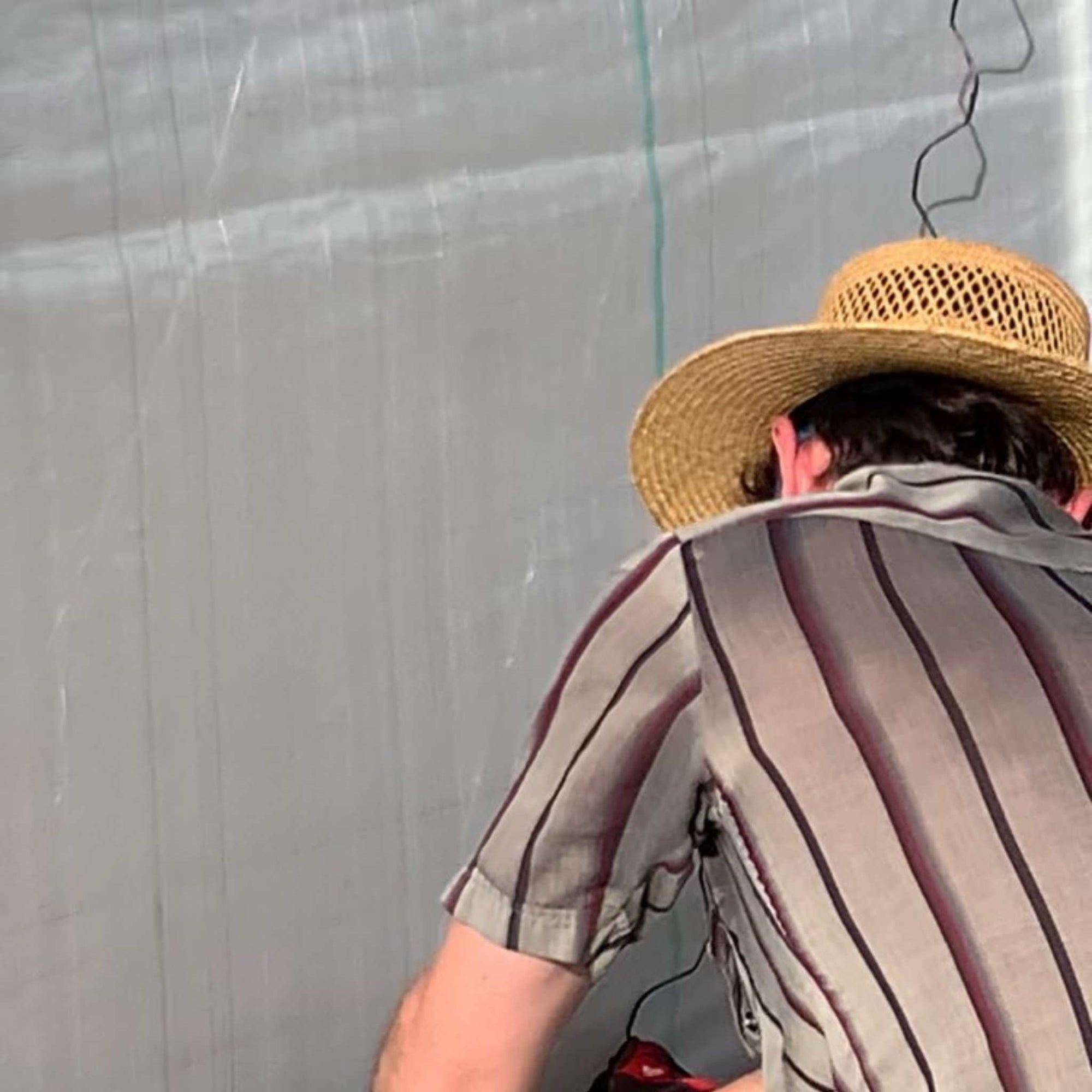 Closeup of Grower Installing Solarig Woven Greenhouse Plastic