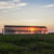 USA-made 20-foot wide all-metal hoop house with shade cloth and clear plastic, captured at sunset. The structure emphasizes sustainability, offering a perfect solution for extending the growing season in various climates.