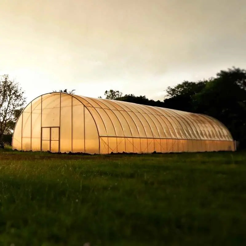 30' All metal round hoop house protecting crops on a market farm